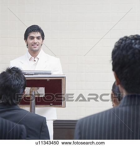 Stock Image - Businessman giving presentation in a conference room. Fotosearch
