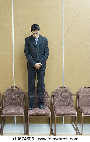 Businessman standing on a chair View Large Photo Image Stock Photograph - Businessman standing on a chair. Fotosearch