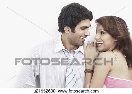 Stock Image - Businessman standing with a young woman leaning on him. Fotosearch