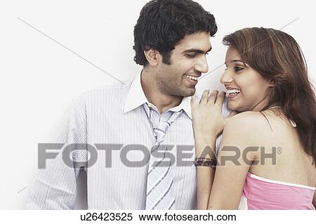 Stock Photography - Businessman standing with a young woman leaning on him. Fotosearch