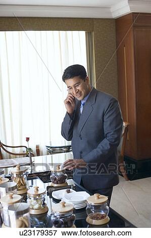 Stock Photo - Businessman talking on a mobile phone and smiling. Fotosearch