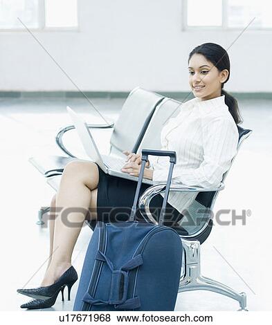 Businesswoman sitting and using a laptop View Large Photo Image Stock Photo - Businesswoman sitting and using a laptop. Fotosearch