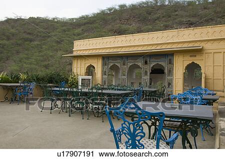 Stock Image - Chairs and tables at an open air restaurant. Fotosearch