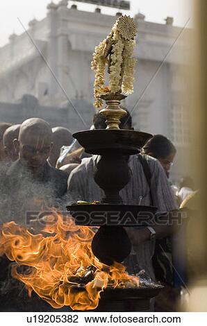 Stock Image - Close-up of a burning oil lamp, Tirupati, Tirumala Venkateswara Temple, Tirumala, Andhra Pradesh, India. Fotosearch