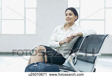 Close-up of a businesswoman sitting at an airport and looking away View Large Photo Image Stock Image - Close-up of a businesswoman sitting at an airport and looking away. Fotosearch