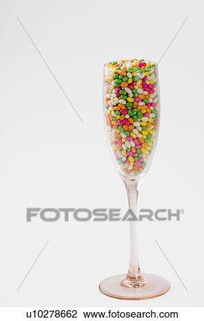 Stock Image - Close-up of a champagne flute filled with jellybeans. Fotosearch