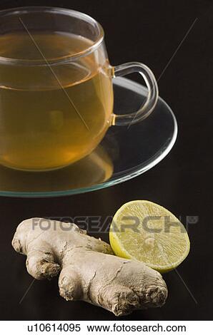 Stock Photography - Close-up of a cup of herbal tea with a ginger and a lemon slice. Fotosearch