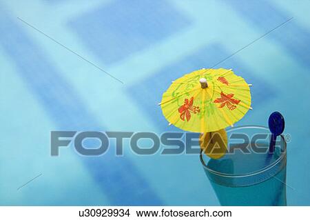 Close-up of a drink umbrella in a glass of juice View Large Photo Image Picture - Close-up of a drink umbrella in a glass of juice. Fotosearch