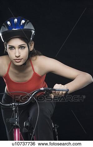 Close-up of a female cyclist riding a bicycle View Large Photo Image Stock Photograph - Close-up of a female cyclist riding a bicycle. Fotosearch