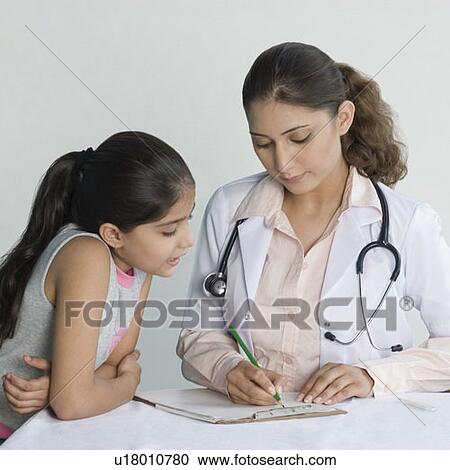 Close-up of a female doctor writing a medical report and a girl standing beside her View Large Photo Image Stock Image - Close-up of a female doctor writing a medical report and a girl standing beside her. Fotosearch