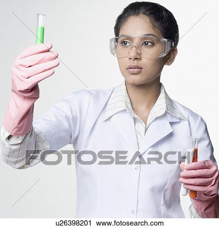 Stock Image - Close-up of a female lab technician looking at a test tube. Fotosearch