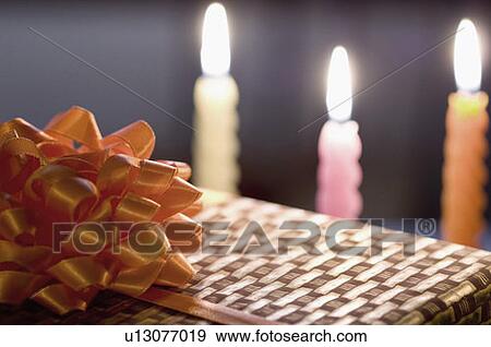 Close-up of a gift with burning candles View Large Photo Image Stock Photo - Close-up of a gift with burning candles. Fotosearch