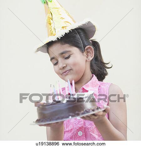 Close-up of a girl holding a birthday cake and smiling View Large Photo Image Stock Photograph - Close-up of a girl holding a birthday cake and smiling. Fotosearch