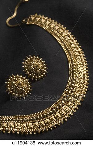 Stock Photography - Close-up of a golden necklace with earrings. Fotosearch