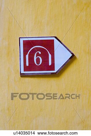 Picture - Close-up of a headphones symbol on a wall. Fotosearch