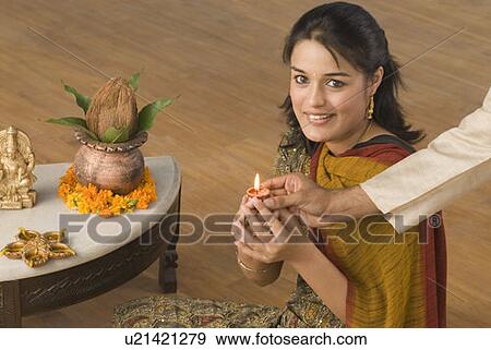 Close-up of a man's hand giving an oil lamp to a young woman View Large Photo Image Stock Photo - Close-up of a man's hand giving an oil lamp to a young woman. Fotosearch