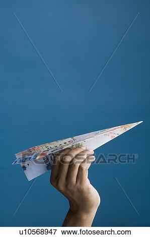 Close-up of a person's hand flying a paper airplane View Large Photo Image Stock Photo - Close-up of a person's hand flying a paper airplane. Fotosearch