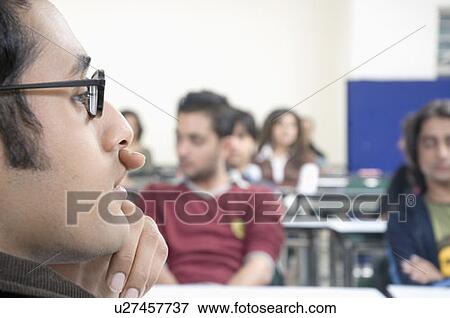 Close-up of a professor sitting in a lecture hall with his hand on his chin View Large Photo Image Stock Photo - Close-up of a professor sitting in a lecture hall with his hand on his chin. Fotosearch