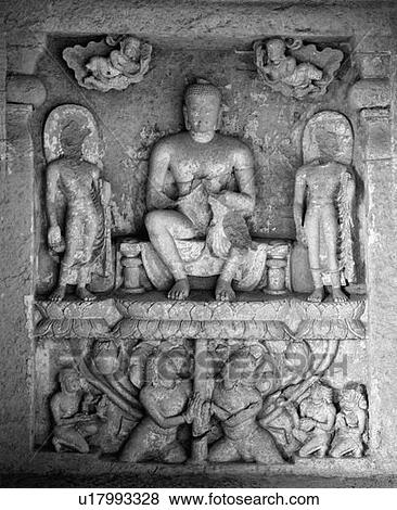 Stock Photo - Close-up of a statue of Buddha sitting on a Lotus flower carved on the wall of a cave, Kanari Cave, Mumbai, Maharashtra, India. Fotosearch
