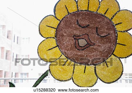 Stock Image - Close-up of a sunflower painted on a window pane. Fotosearch