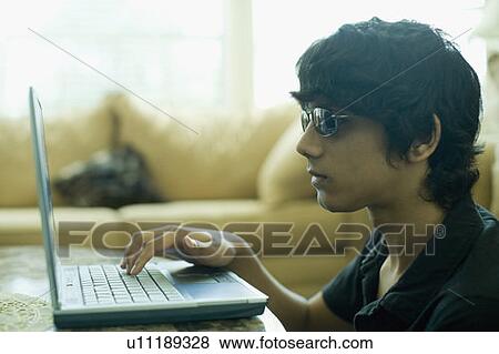 Close-up of a teenage boy using a laptop View Large Photo Image Stock Photo - Close-up of a teenage boy using a laptop. Fotosearch