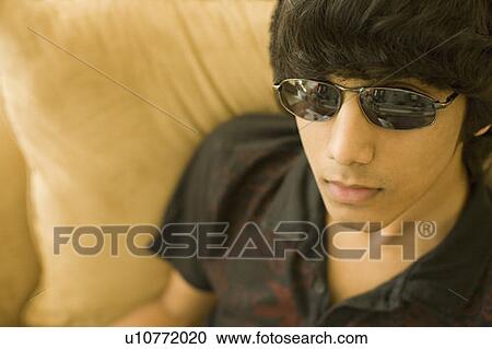 Close-up of a teenage boy wearing sunglasses View Large Photo Image Stock Image - Close-up of a teenage boy wearing sunglasses. Fotosearch