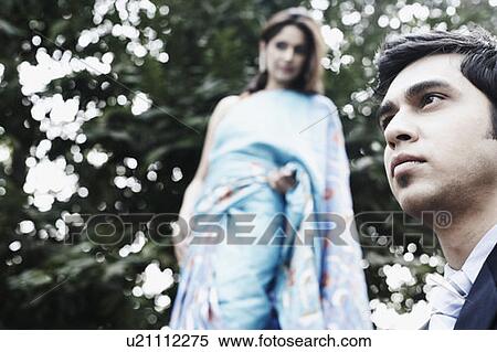 Stock Photography - Close-up of a young man with a young woman behind him. Fotosearch