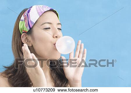 Stock Photo - Close-up of a young woman blowing bubble gum. Fotosearch