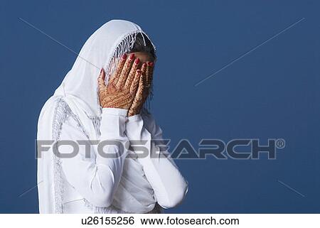 Stock Photograph - Close-up of a young woman covering her face with her hands. Fotosearch