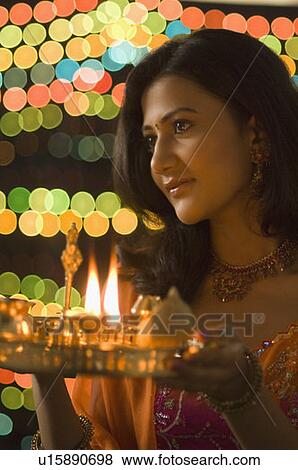 Stock Photo - Close-up of a young woman holding a diwali thali. Fotosearch