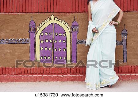 Close-up of a young woman leaning against a wall View Large Photo Image Stock Image - Close-up of a young woman leaning against a wall. Fotosearch