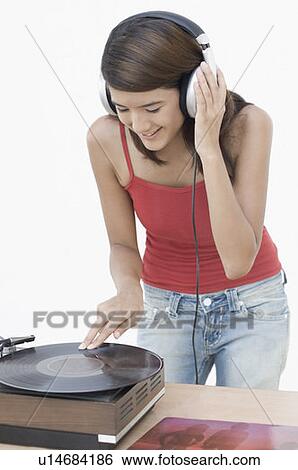 Close-up of a young woman listening to music and bending over a gramophone View Large Photo Image Stock Photograph - Close-up of a young woman listening to music and bending over a gramophone. Fotosearch