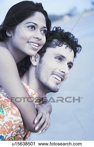 Close-up of a young woman riding piggyback on a young man and smiling View Large Photo Image Stock Image - Close-up of a young woman riding piggyback on a young man and smiling. Fotosearch