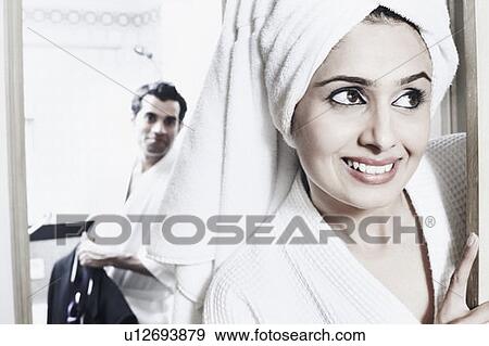 Close-up of a young woman smiling with a young man behind her View Large Photo Image Stock Photo - Close-up of a young woman smiling with a young man behind her. Fotosearch