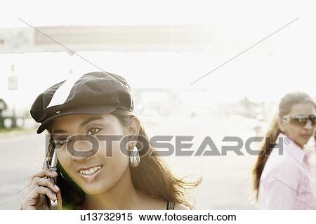 Close-up of a young woman talking on a mobile phone View Large Photo Image Stock Photography - Close-up of a young woman talking on a mobile phone. Fotosearch