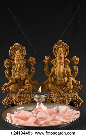 Close-up of an oil lamp and flower petals in front of Hindu gods View Large Photo Image Stock Photography - Close-up of an oil lamp and flower petals in front of Hindu gods. Fotosearch