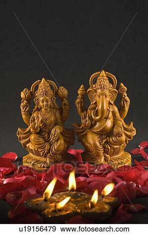 Close-up of an oil lamp burning in front of religious idols View Large Photo Image Stock Photo - Close-up of an oil lamp burning in front of religious idols. Fotosearch