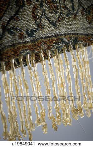 Stock Image - Close-up of beads hanging on a fabric. Fotosearch
