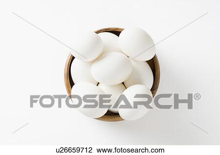 Stock Image - Close-up of eggs in a wooden bowl. Fotosearch