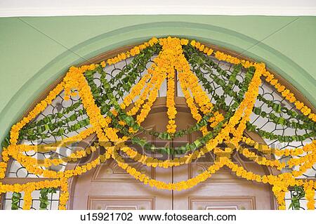 Stock Image - Close-up of flower garlands hanging on a doorway. Fotosearch