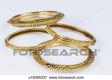 Stock Photo - Close-up of golden bracelets. Fotosearch