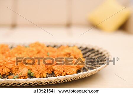 Stock Image - Close-up of Marigolds in a wicker plate. Fotosearch