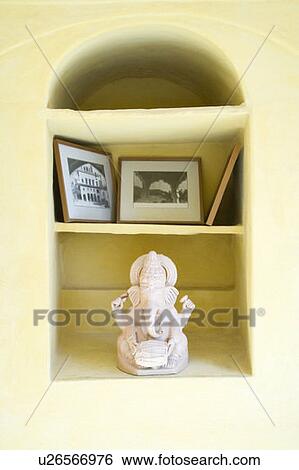 Stock Photograph - Close-up of picture frames and a statue of Lord Ganesha. Fotosearch