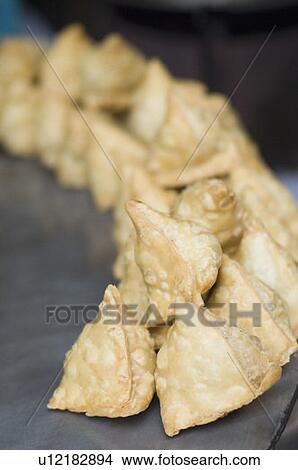 Picture - Close-up of samosas on a tava. Fotosearch