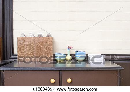 Close-up of stacks of bowls and a vase with bottles on a cabinet View Large Photo Image Stock Photo - Close-up of stacks of bowls and a vase with bottles on a cabinet. Fotosearch