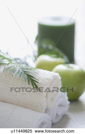 Stock Photography - Close-up of towels with two apples and a candle. Fotosearch