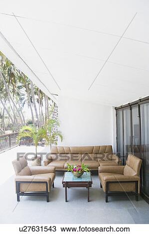 Stock Image - Couch with a table in a balcony. Fotosearch