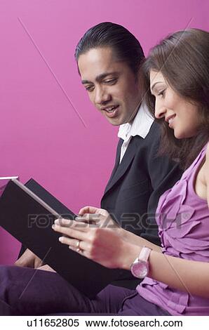 Couple looking at a menu and smiling View Large Photo Image Stock Photography - Couple looking at a menu and smiling. Fotosearch