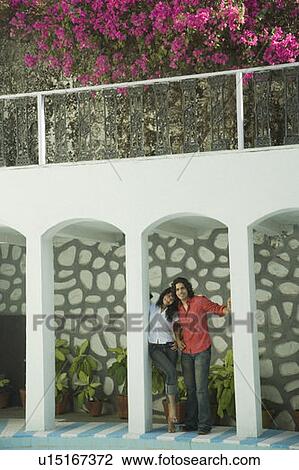 Stock Image - Couple standing at a poolside. Fotosearch