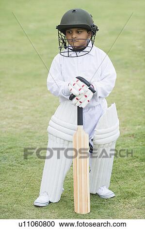Stock Image - Cricketer standing in a cricket field. Fotosearch